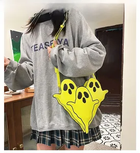 Détail d'un sac bandoulière fantôme jaune tendance porté par un mannequin en style décontracté