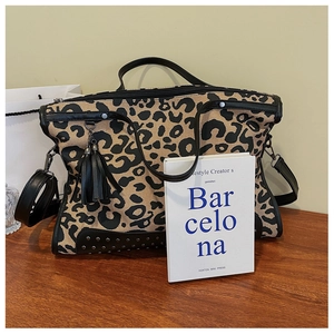 Dettaglio della borsa leopardata con nappe in pelle nera e borchie in metallo tondo