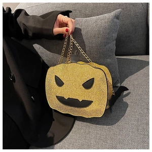 Detail of sequin pumpkin bag showing golden glitter texture and metallic chain strap