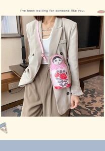 Detailed view of pink Russian Matryoshka doll crossbody bag with floral prints