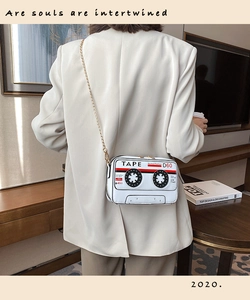 Retro white cassette tape crossbody bag with gold chain strap shown on model shoulder