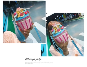 Detail of cupcake crossbody bag featuring striped pattern and cherry embroidery