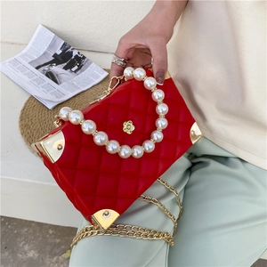 Red quilted box bag with large pearl handle, floral gold clasp and metal chain strap