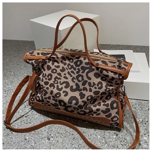Dettaglio della borsa tote leopardata con borchie metalliche e manici in pelle marrone