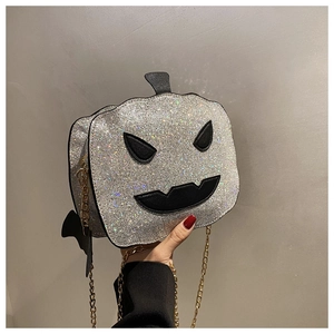 Detail of silver rhinestone pumpkin bag with black devil face and gold chain strap