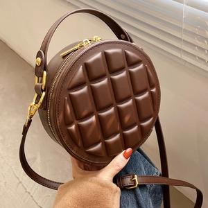 Chocolate brown round quilted crossbody handbag with gold hardware and top handle