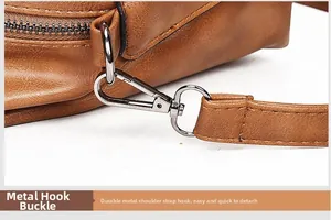 Close-up of durable gunmetal lobster clasp and D-ring on a brown leather Boston bag