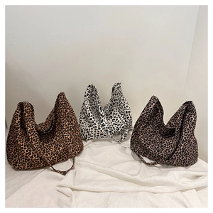 Detailed view of leopard print canvas tote bags in brown, white and dark patterns