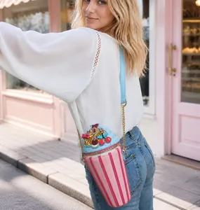 Detailed view of dessert cup shaped shoulder bag with pink stripes and cherry decor