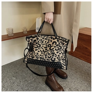 Dettaglio della borsa leopardata con borchie metalliche e nappina in pelle nera
