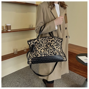 Dettaglio della borsa leopardata con borchie nere sul fondo e ciondolo con frange in pelle