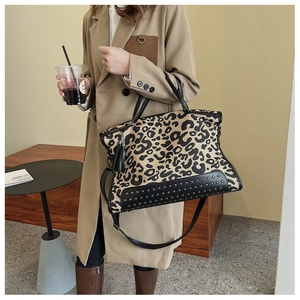Dettaglio della borsa tote leopardata con borchie metalliche e eleganti nappe in pelle