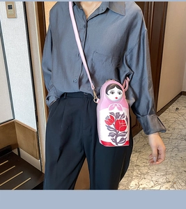Pink Matryoshka doll crossbody bag detail showing top zipper and floral PU leather texture