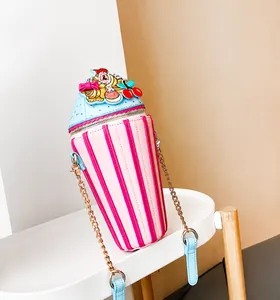 Detail of cupcake-shaped crossbody bag featuring pink stripes and cherry embroidery