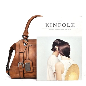 Detail view of caramel brown vintage leather Boston bag with Kinfolk magazine for size