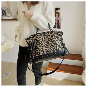Dettaglio della borsa tote leopardata con finiture in pelle nera e borchie argentate