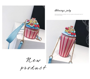 Detail of cupcake themed crossbody bags with pink stripes and decorative cherry accents