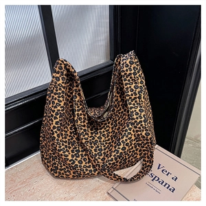 Detailed view of leopard print tote bag with wide strap on marble and striped surface