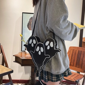 Sac bandoulière noir motif fantôme avec trois visages porté par un mannequin en salle