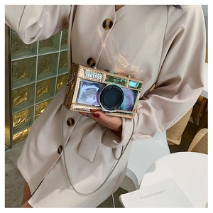 Detail of creative gold metal camera-shaped clutch bag with delicate chain strap and shutter design