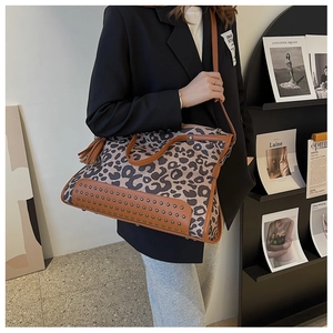 Dettaglio borsa shopper leopardata con borchie metalliche, frange in pelle e tracolla