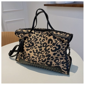 Dettaglio della borsa leopardata con borchie metalliche e nappina nera decorativa