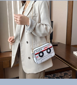 Close-up of vintage white cassette tape crossbody bag with red and black print detail
