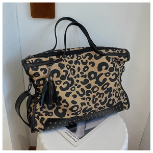 Dettaglio della borsa tote leopardata con borchie metalliche, frange in pelle e cerniera