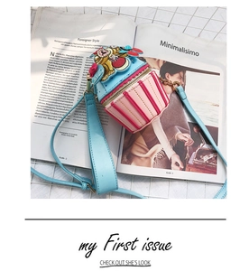 Detail of cupcake-shaped shoulder bag featuring floral embroidery and striped textures