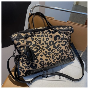 Dettaglio della borsa leopardata con borchie argentate e ciondolo a nappe nere