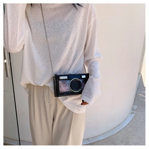 Detail view of a black retro camera-shaped box bag with a silver chain shoulder strap