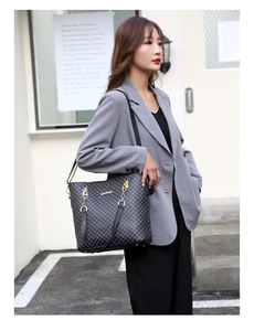 Detail of grey geometric tote bag with gold chain strap on a professional female model