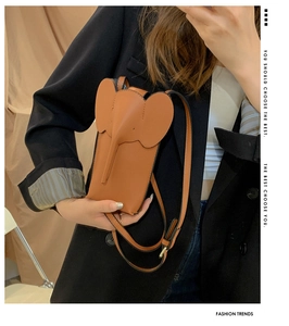 Detail of a brown elephant-shaped crossbody phone bag with adjustable leather strap