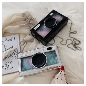 Detail of creative camera-shaped chain bags with transparent windows and colorful feathers
