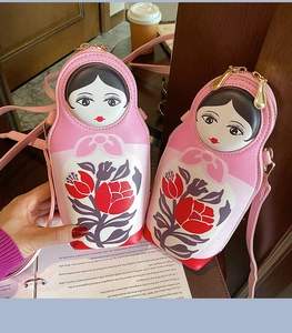 Detail of pink PU leather Russian doll crossbody bags with floral patterns and gold zippers