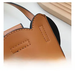 Close-up of precise stitching on brown leather handbag with smooth black edge finish