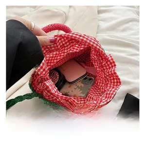 Detail shot of straw woven beach bag interior with red checkered lining and ample storage