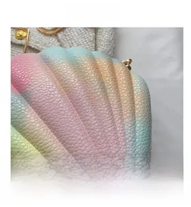 Detail shot of rainbow gradient shell bag showing premium lychee leather texture and gold chain