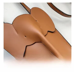 Detail showing the brown elephant-shaped leather mini bag with high-quality stitching