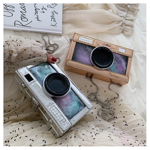 Detail of creative camera-shaped chain bags in silver and gold with colorful feathers
