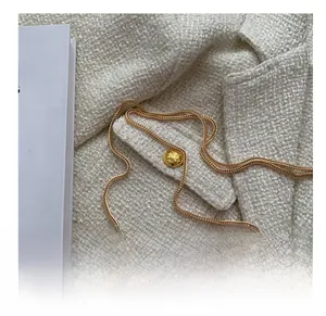 Detail of pink and blue gradient shell bag with textured pearl finish and gold chain