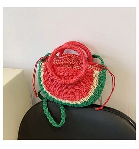 Detail of watermelon straw bag showing woven texture and red checkered drawstring lining