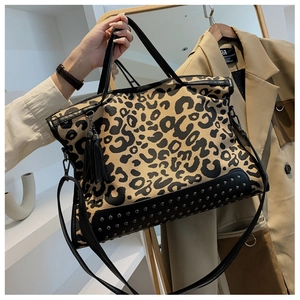 Borsa tote francese maculata con borchie argento e nappine in pelle portata a mano