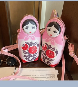 Detail of pink nesting doll PU crossbody bags with floral print and gold zippers