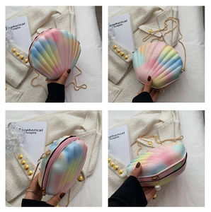 Detail view of rainbow gradient shell bag with gold chain and white pearl charms