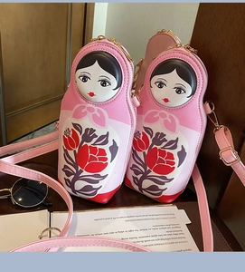 Detail of pink Russian doll crossbody bags with floral patterns and gold zippers