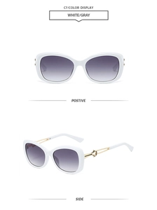Detail of white butterfly frame sunglasses with gold twisted metal hinges and gradient lenses