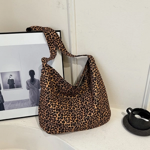 Stylish leopard print canvas shoulder bag for women with wide strap in a minimalist setting