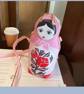 Detailed close-up of pink Russian nesting doll PU crossbody bag with golden zipper