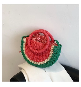 Detail of watermelon-shaped woven straw bag with red round handles and gingham lining